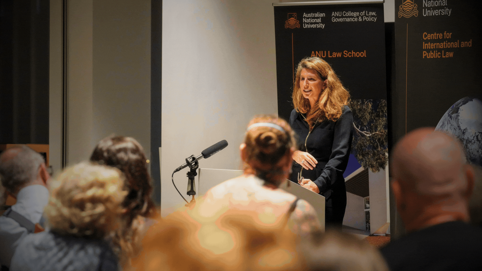Professor Devika Hovell delivering the Annual Kirby Lecture in International Law at ANU Law School to a seated audience.