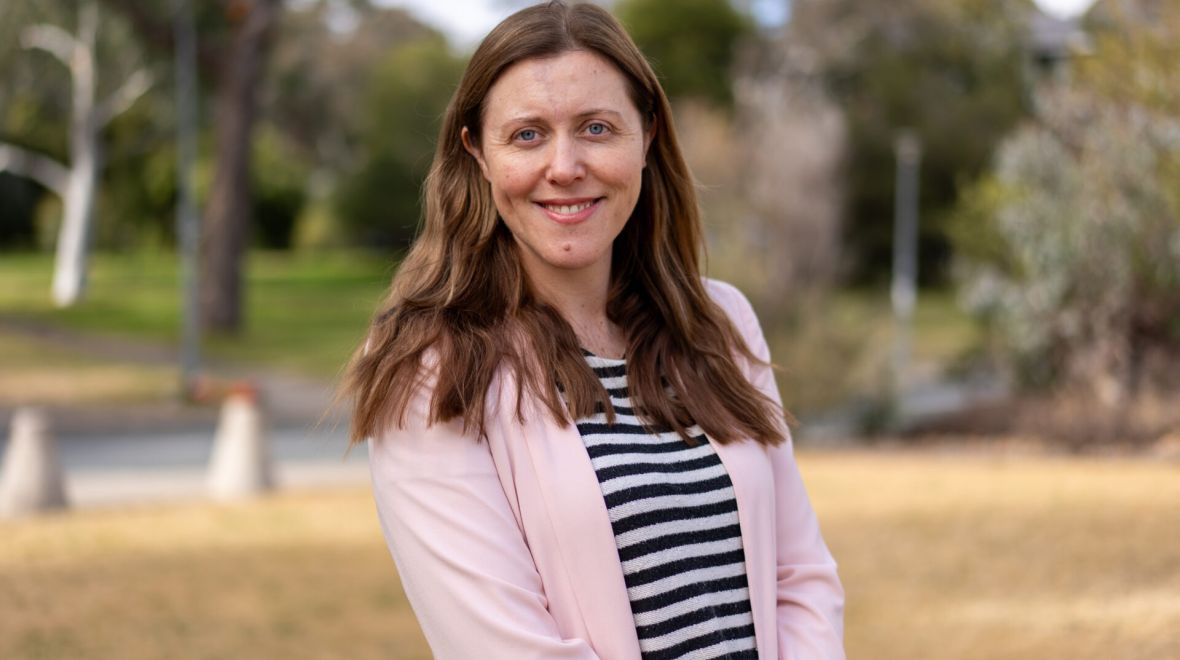 Portrait of Dr Claire Hansen standing outdoors on the ANU campus.