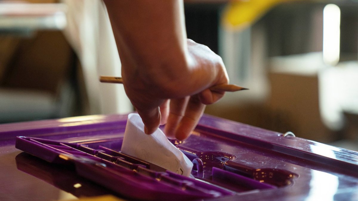 Image of someone putting in their ballot 