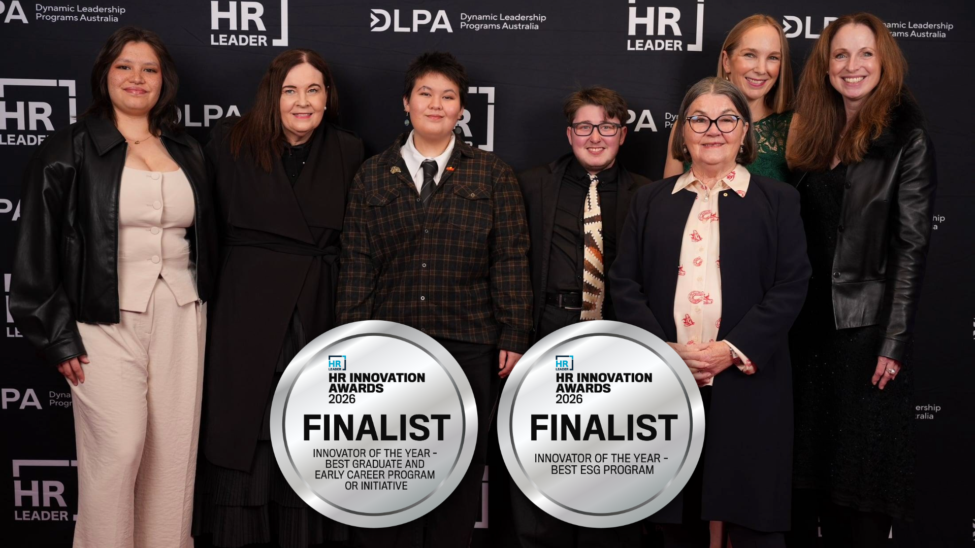 Seven people smiling at the HR Innovation Awards, with two silver finalist badges overlaid on the photo.