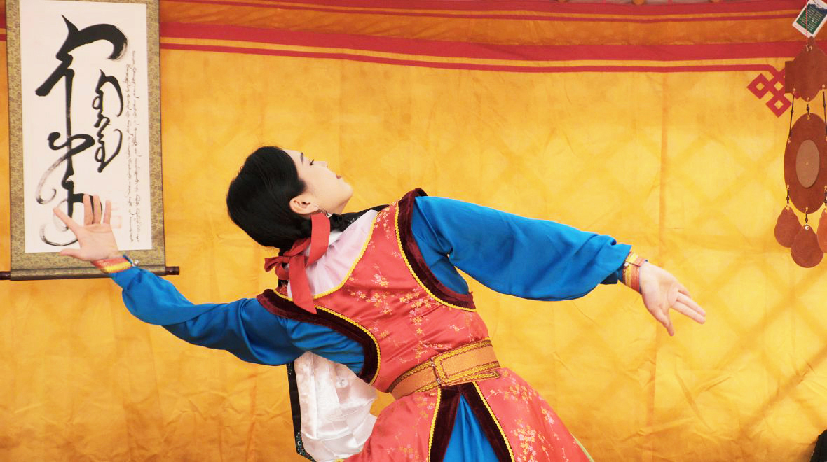 Woman in traditional dress dancing in Yurt