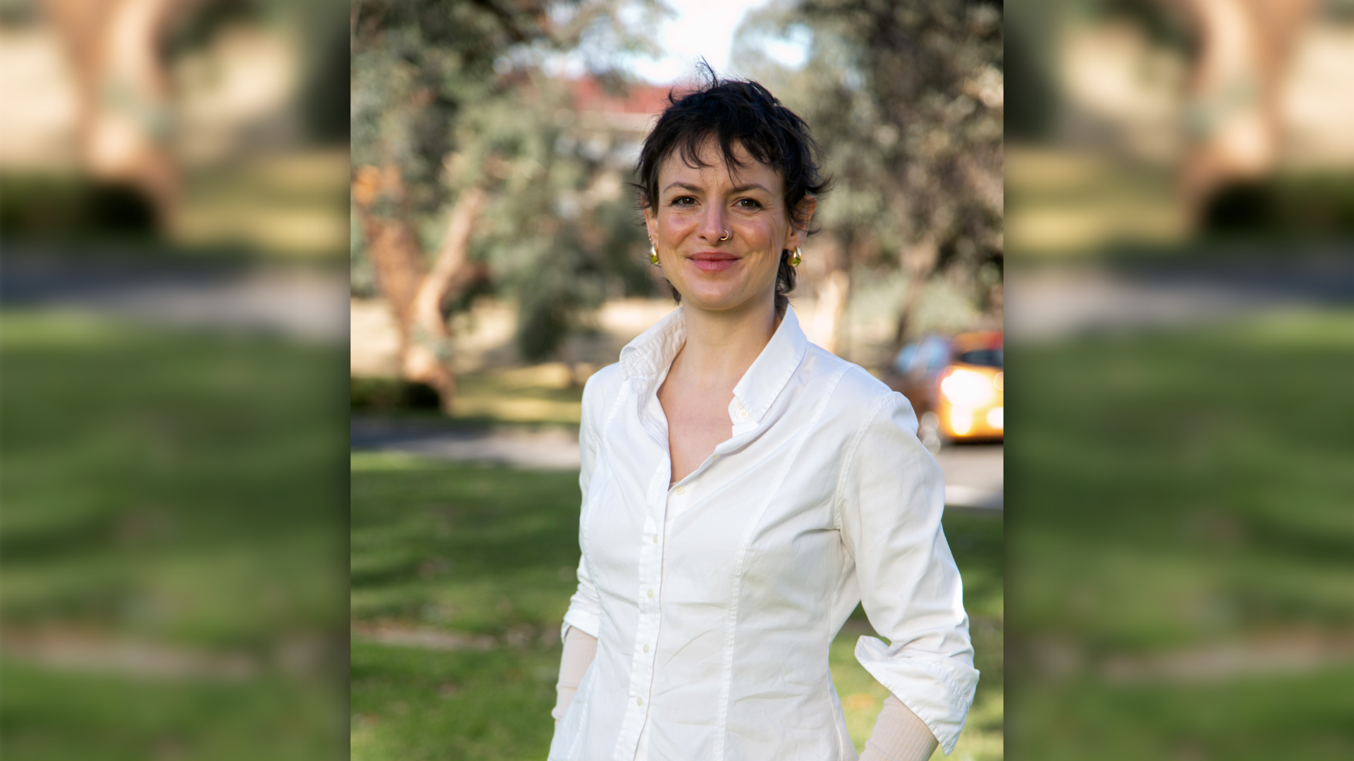 Alex Gotts smiles at the camera while standing outdoors on the ANU campus.