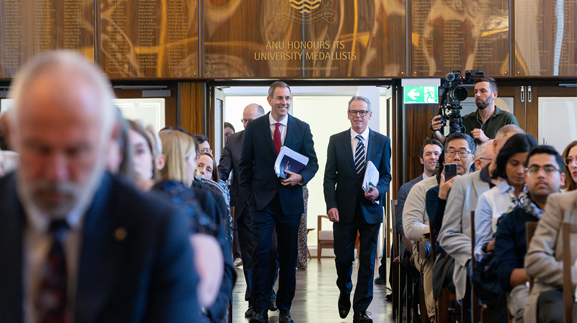 Treasurer The Hon Dr Jim Chalmers smiles as he walks between rows of seated attendees at University Hall for the Australia and the World Annual Lecture.