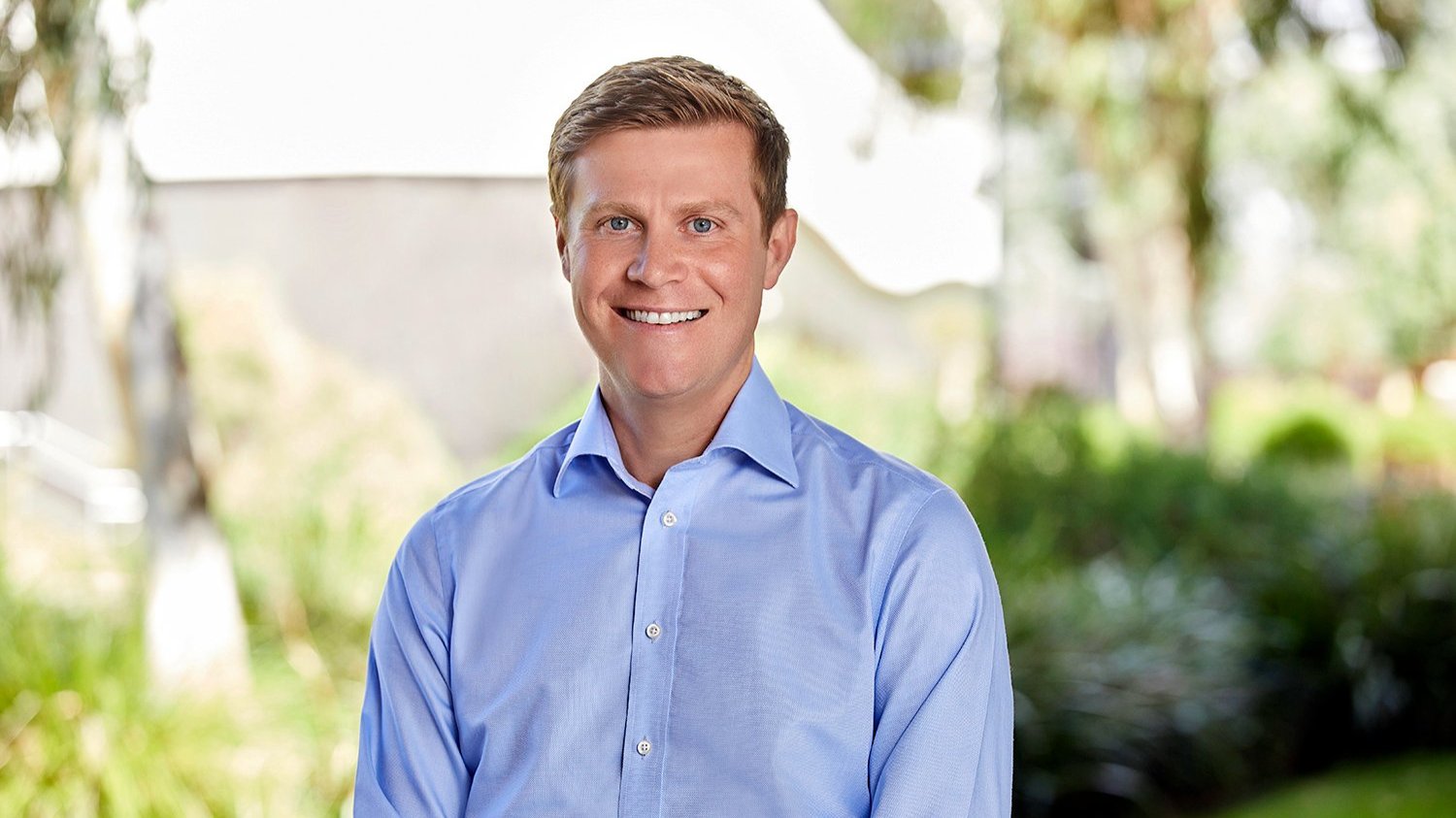 Professor Christian Downie standing outdoors on campus.