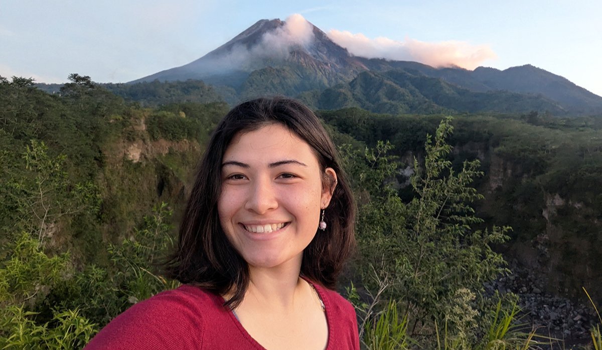 Amber Chen smiling in front of Mount Merapi in Indonesia.